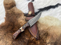 Decorative knife with leather sheath on a fur surface